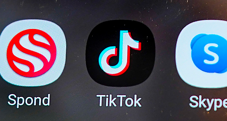 Vi ser en skärm på en mobil. Det är en närbild. I mitten är appen för Tiktok. Till vänster är appen Spond. Till höger är appen Skype.