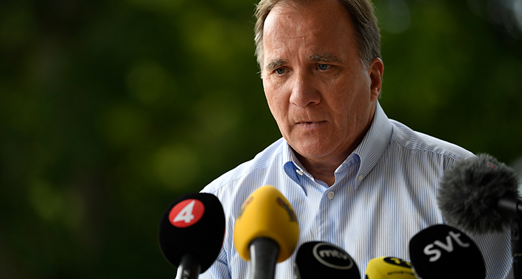 Statsminister Stefan Löfven pratar i flera mikrofoner från olika medier.