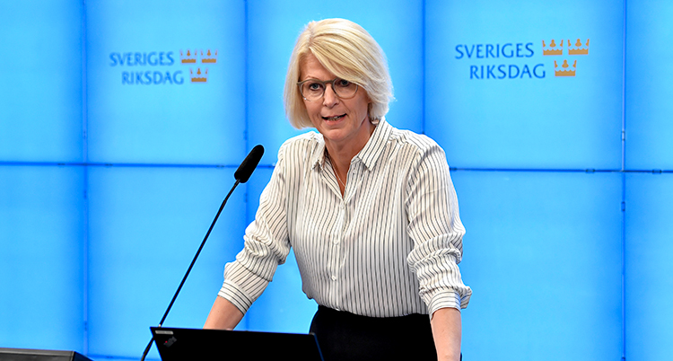 Sventesson står i talarstolen. Bakom henne står det Sverige riksdag på väggen.