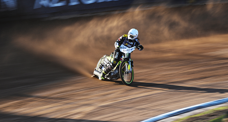 En förare som kör speedway på en bana.