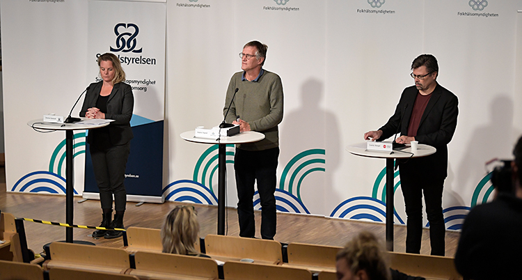 Tre personer står på en scen. Till vänster står Johanna Sandwall, i mitten står Anders Tegnell och till höger står Svante Werger.