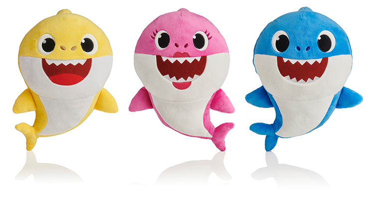 En gul, en rosa och en blå animerad haj som står intill varandra och alla ler med röda glada munnar