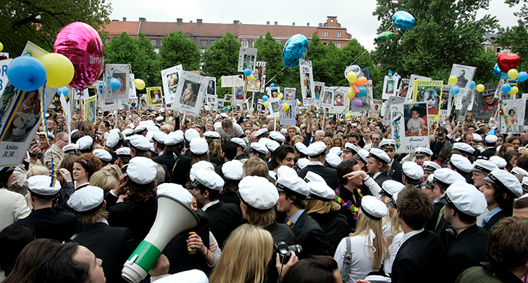 En bild på massor av studenter i vita mössor.