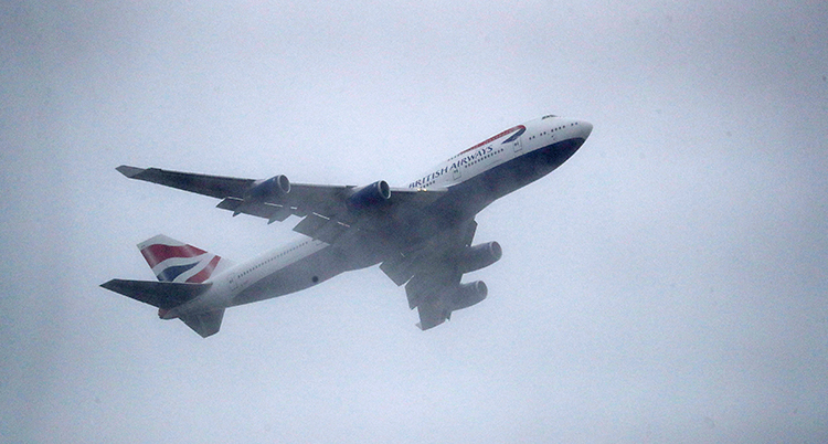Ett brittiskt flygplan flyger i luften. Det står British Airways på flygplanet.
