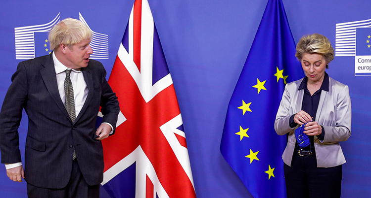 Johnson står framför en brittisk flagga och tittar van der Leyen. Hon viker ihop ett munskydd. Bakom henne är EUs flagga.