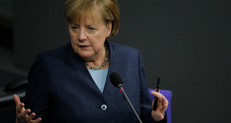Angela Merkel vid en mikrofon.