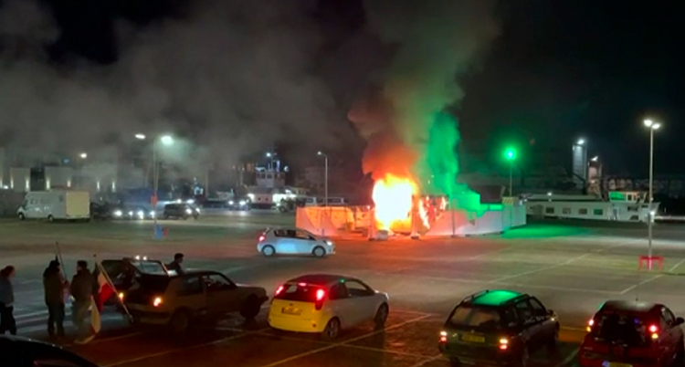 Ett litet hus brinner på en stor parkeringsplats.