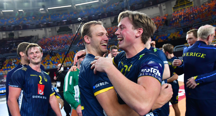 Två svenska spelare kramar varandra och skrattar.