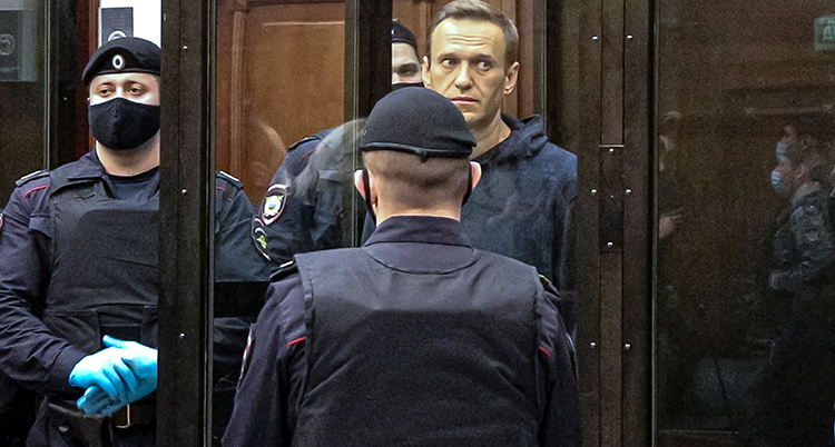 Navalnyj i en glasbur i domstolen bevakad av poliser.