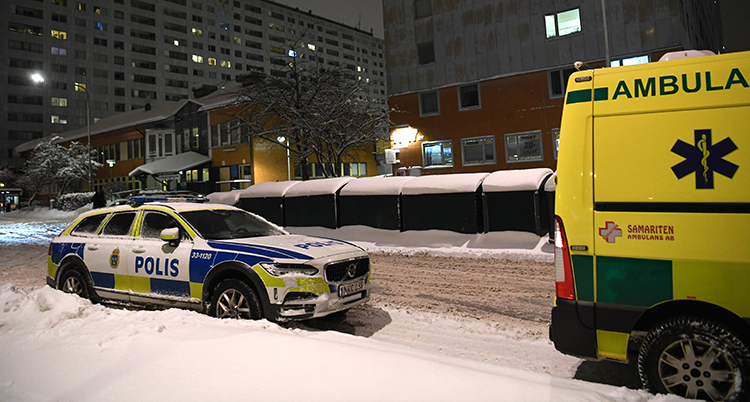 En polis och en ambulans parkerade på en gata i ett bostadsområde.