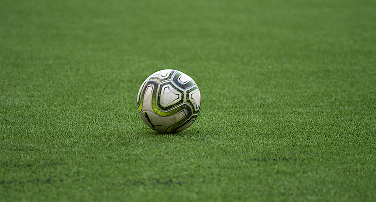 En fotboll ligger på en fotbollsplan.
