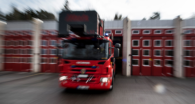 Bilen åker ut från ett stort rött garage.