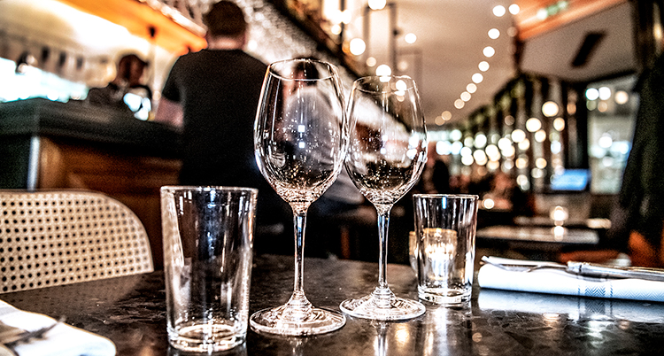 En nära bild på två tomma vinglas på ett bord på en restaurang.