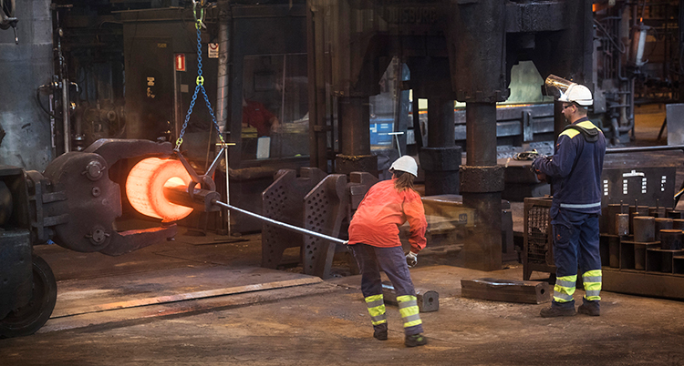 De jobbar med glödande stål i en fabrik