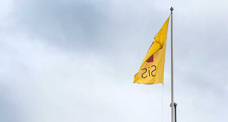 en gul flagga på en flaggstång. Det står Sis på flaggan.