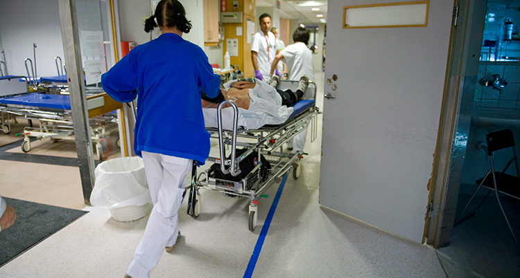 en personal drar en patient i en säng