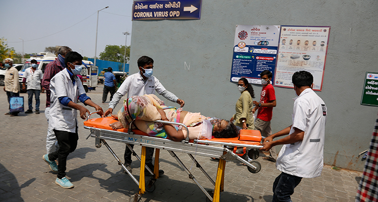 En kvinna rullas in på ett sjukhus på en bår av personal.