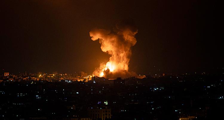 Det är natt i Gaza. Det är mörkt. Man ser ljus från fönster. Långt bort är det en explosion. Det kommer eld och rök.