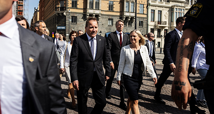 Stefan Löfven och några andra i regeringen går utomhus i Stockholm. De är på väg till riksdagen.