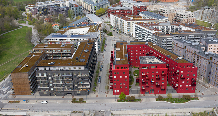 En flygbild över ett område med stora hus. Ett av dem är helt i rött.