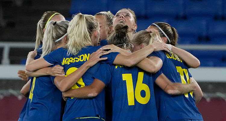 De svenska spelarna står i en ring och kramar varandra.