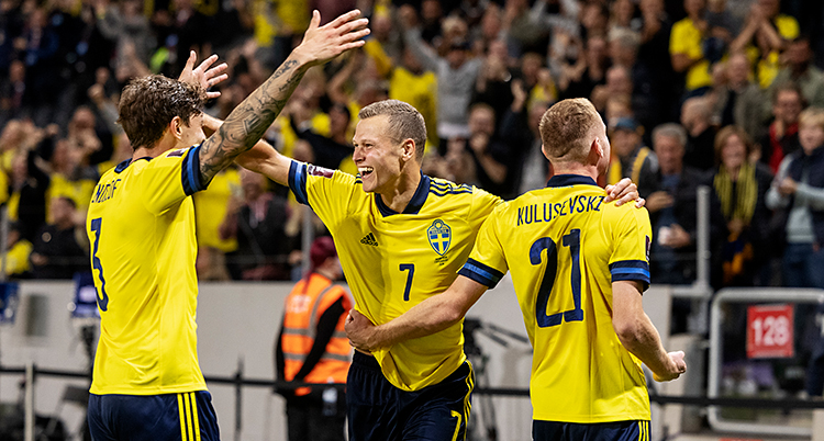 Från en match i fotboll. Viktor Claesson firar sitt mål med två andra spelare. De har gula tröjor. i bakgrunden syns publiken.