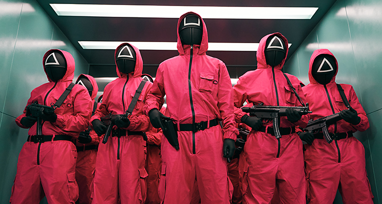 Vakter i rosa kläder och masker för ansikter. De har vapen.