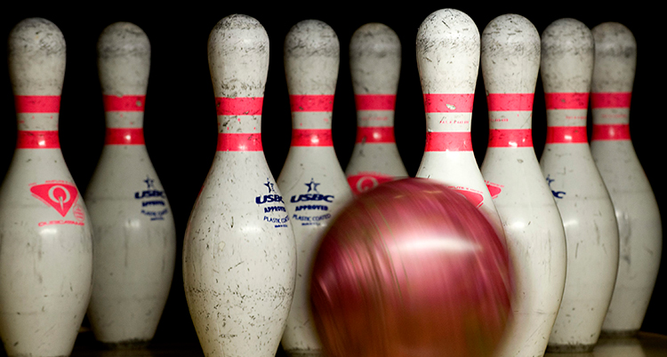Ett bowlingklot är på väg att rulla mot käglorna.