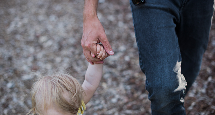 en vuxen håller ett barn i handen.