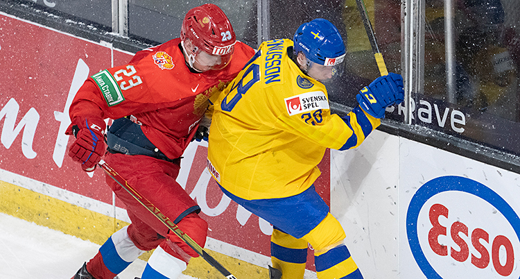 Två spelare kämpar om pucken i en match i ishockey.