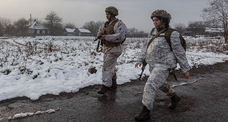 Soldater med vapen och vita kläder. Det är snö bakom dem.