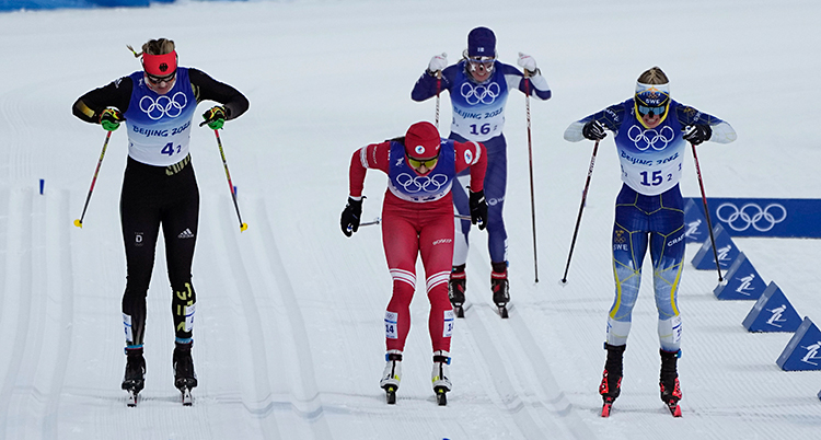 Fyra åkare kör på upploppet i stafetten i sprint på skidor.