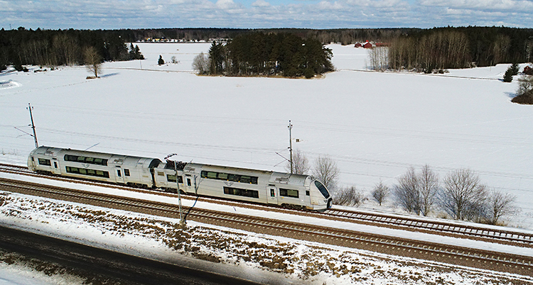 Ett tåg som åker genom ett vinterlandskap.