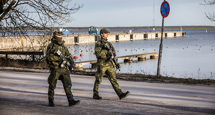Två soldater går på en väg vid havet, på Gotland.
