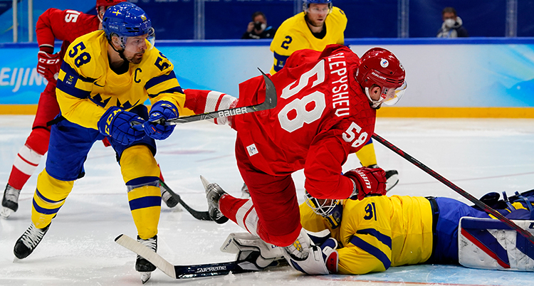 En rysk spelare vid Sveriges mål. En back försöker att stoppa honom.