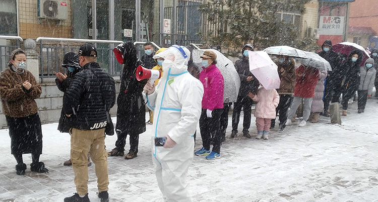 Människor i staden Jilin i Kina står i kö för att testa sig för viruset corona.
