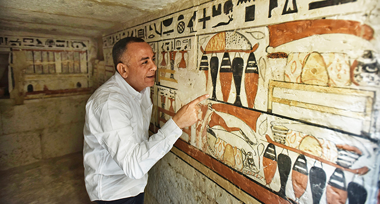 Mostafa Waziri från Egypten tittar på bilder i en gammal grav.