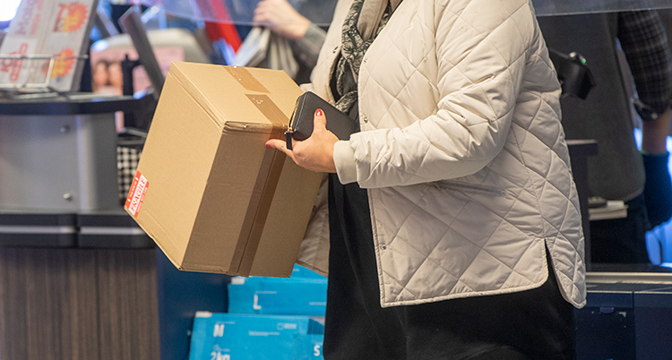 En person håller i ett brunt paket