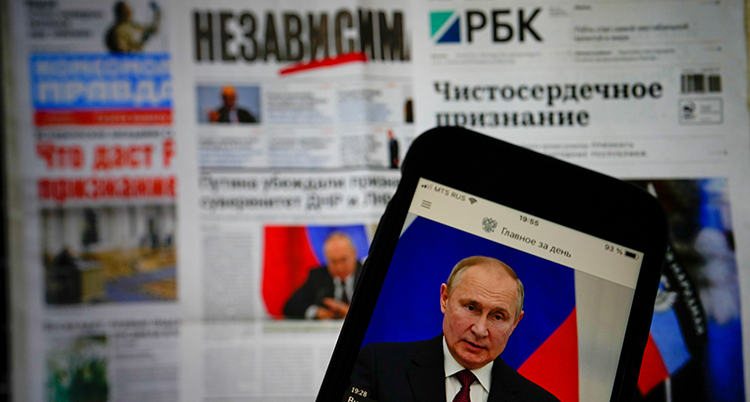 En tidning och en mobil där Putin syns.