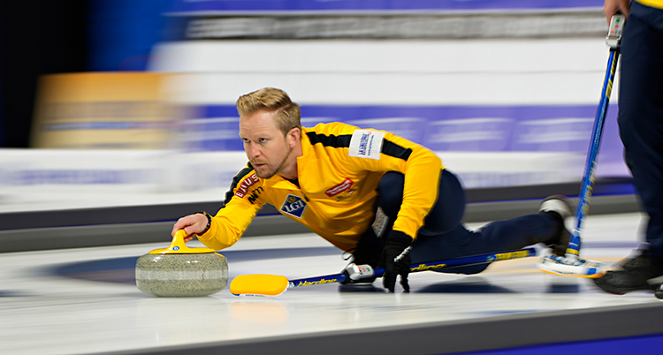Från en match i curling. Niklas Edin släpper iväg en sten på isen.
