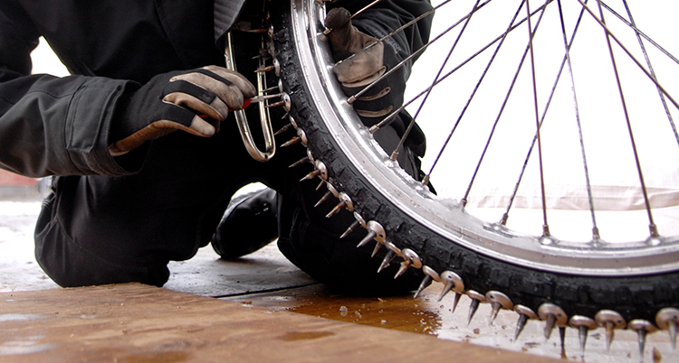 en del av ett hjul på en motorcykel med väldigt stora och spetsiga dubbar