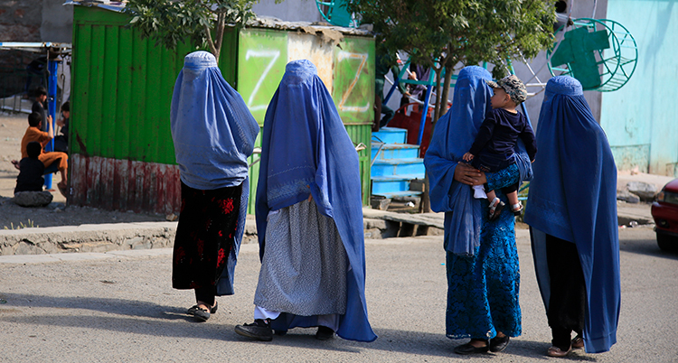 Kvinnor i heltäckande slöja går på en gata i Afghanistan.