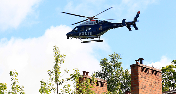 En helikopter är i luften. Det står Polis på helikoptern.