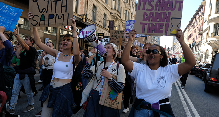 en grupp unga går i en stor demonstration för klimatet.