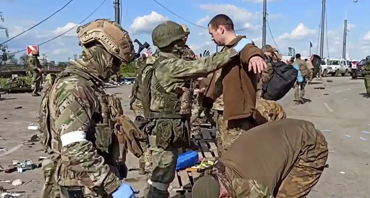 Ryska soldater kontrollerar tillfångatagna soldater från Ukraina.