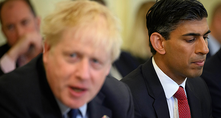 Boris Johnson och Rishi Sunak och flera andra sitter vid ett bord och har ett möte.