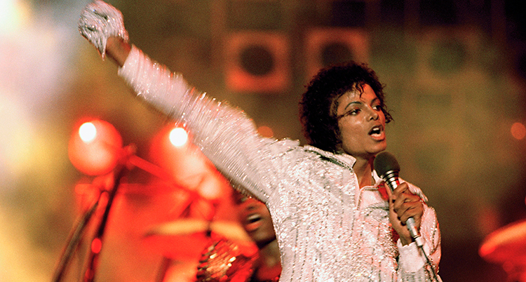 Michael Jackson står på en scen och sjunger i en mikrofon.