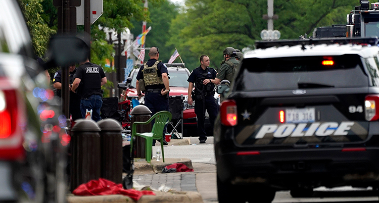 Övergivna tältstolar och barnvagnar på gatan där det hände. Poliser och polisbilar står på gatan.