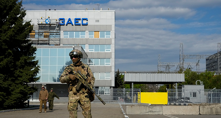 En soldat längst fram i bild. Längst bak syns en byggnad.
