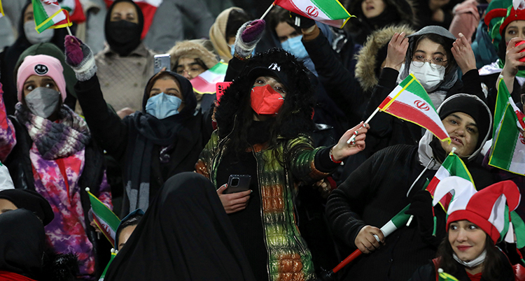 Kvinnor viftar med iranska flaggor.